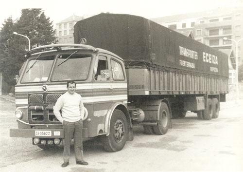 Foto antigua de trabajador delante de un camión